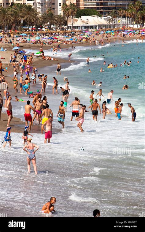 Sunbathers Tourists And Locals Enjoying The Sun Sea And Sand At Playa