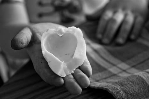 Premium Photo Close Up Of Hand Holding Heart Shape Egg Piece