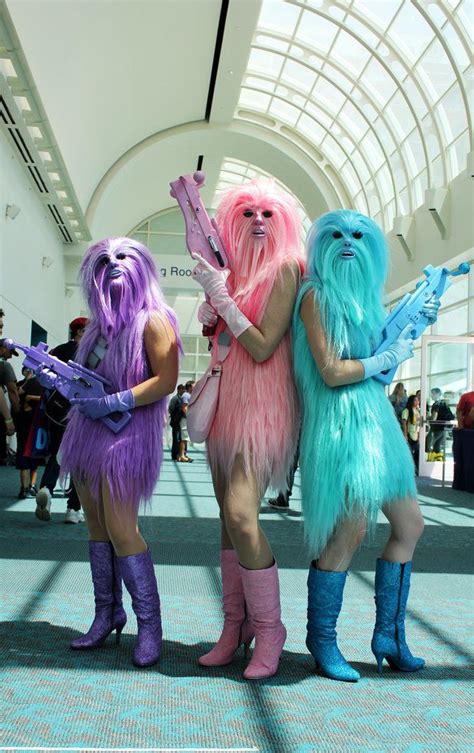 Three Women Dressed In Costumes Standing Next To Each Other