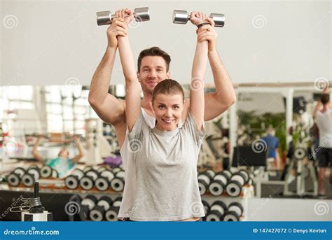 Retrato Dos Pares Bonitos Novos Que Exercitam No Gym Foto De Stock