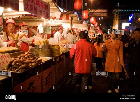 Shoppers Pass Stalls Selling Meat Kebabs And Corn On The Cobs In The