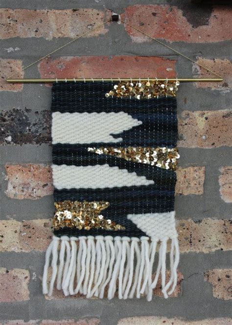 A Wall Hanging With Gold Sequins And Black And White Stripes On It S Side