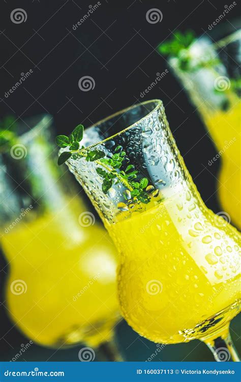 Limoncello With Thyme In Three Grappas Wineglass With Water Drops Close