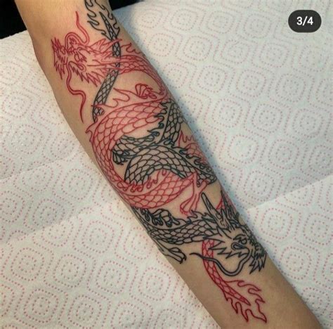 A Tattoo On The Arm Of A Woman With Red And Black Dragon Designs In It