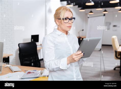 Mature Attractive Businesswoman Standing In Office With Pc Tablet Stock Photo Alamy