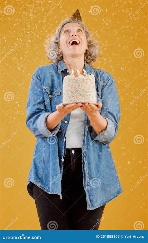 One Happy Mature Caucasian Woman Wearing A Birthday Hat And Holding A
