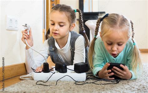 Children Playing With Sockets And Electricity Indoors Stock Photo