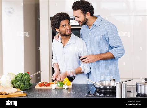 Happy Gay Couple Drinking Wine And Slicing Vegetables Stock Photo Alamy