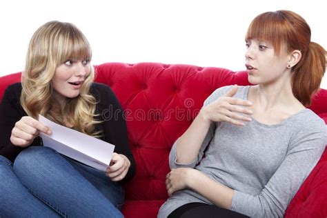 Junge Schöne Blonde Und Rote Behaarte Mädchen Auf Rotem Sofa Haben Eine Co Stockfoto Bild von