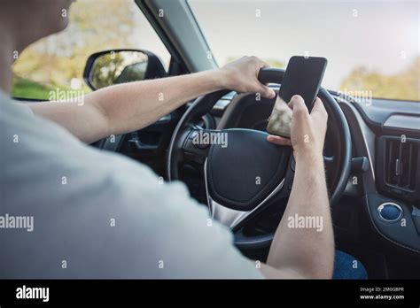 Joven conductor distraído por su teléfono delante del volante