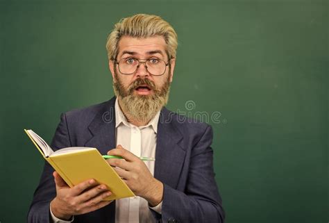 Teacher With Textbook Experienced Teacher Selecting Appropriate