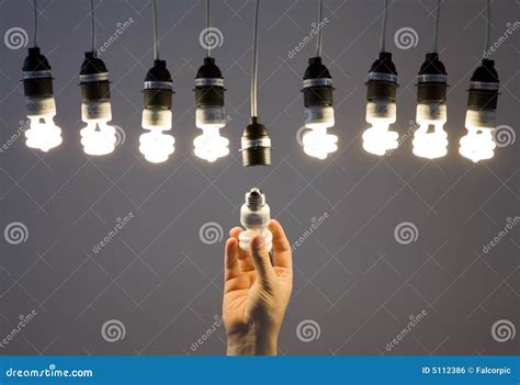 hand replacing light bulb with no background, Hands replacing incandescent light bulb stock image